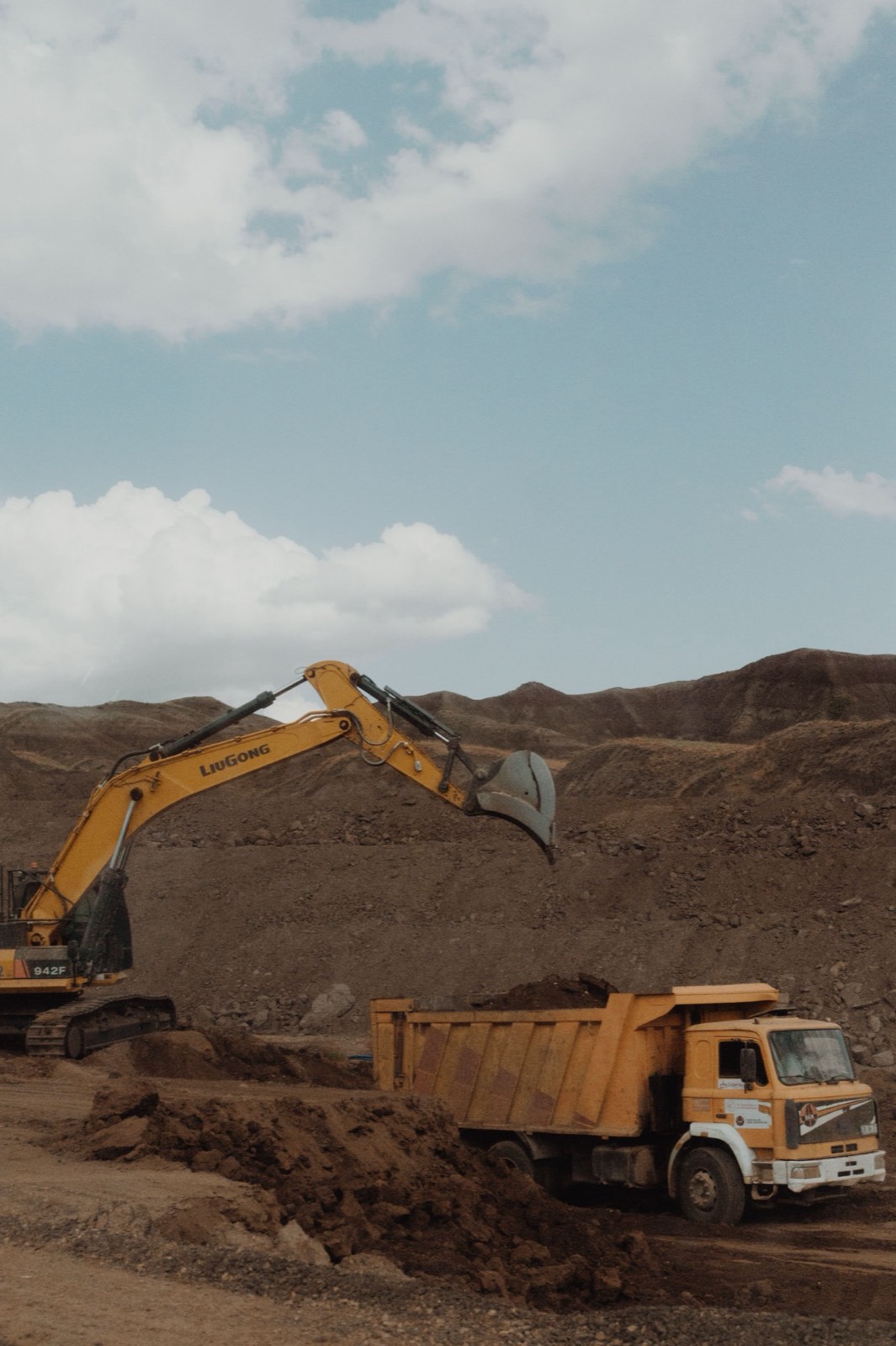 Excavator loading a haul truck on a working bench at a mine.